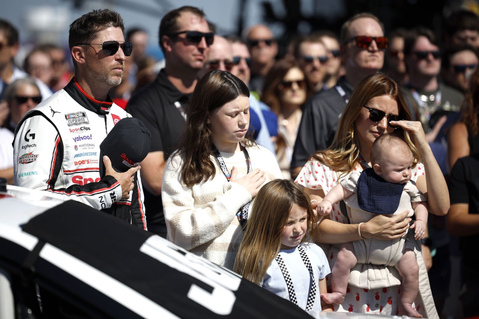 Denny Hamlin, piloto do # 11 Sport Clips Haircuts Toyota, filhas de Jordan Fish, Taylor Hamlin (L) Molly Hamlin e filho Jameson Hamlin durante o hino nacional antes da NASCAR Cup Series Hollywood Casino 400 - Fonte: Getty