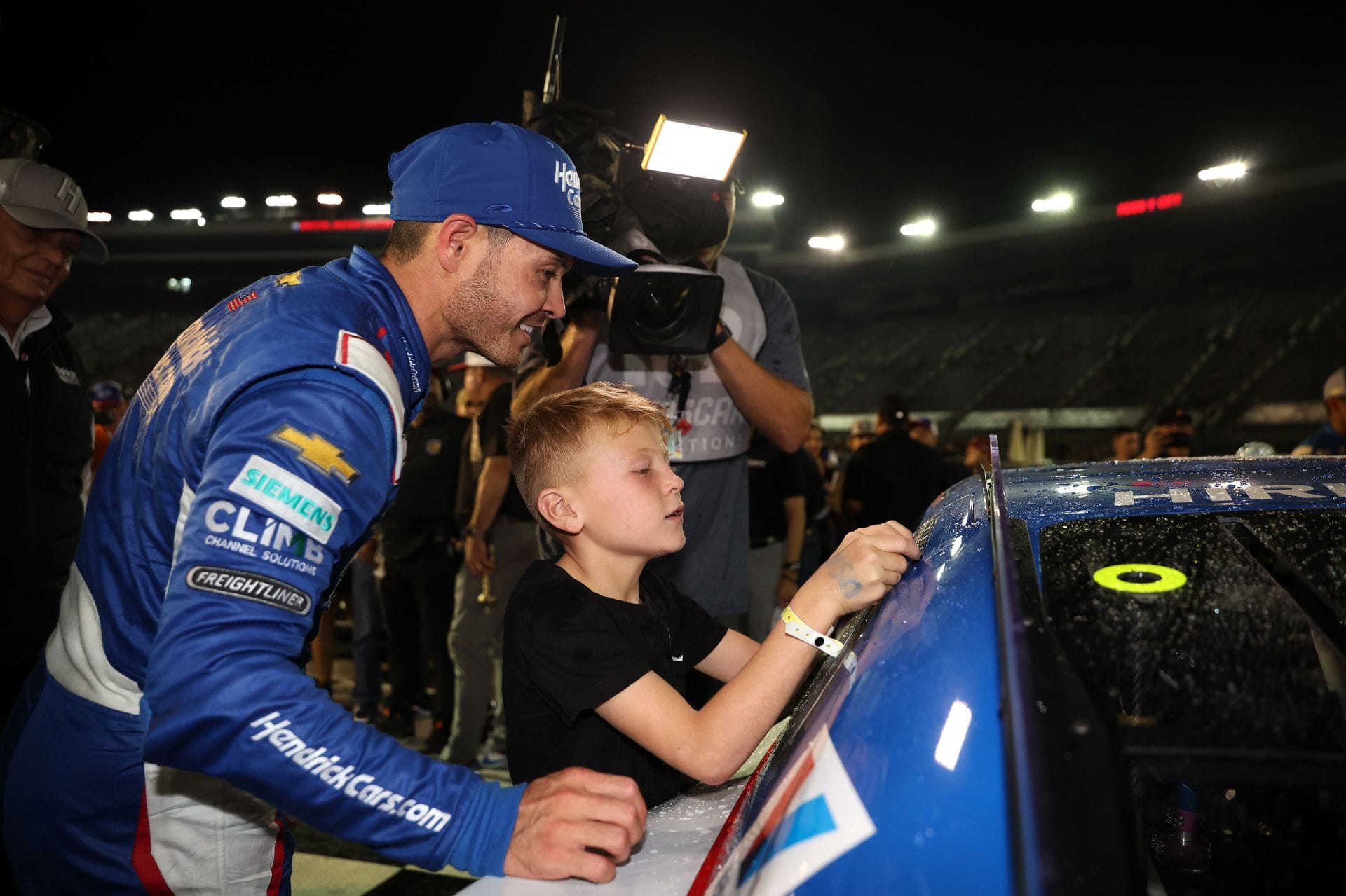 Kyle Larson, driver of the #5 HendrickCars.com Chevrolet, son, Owen Larson places the winner sticker on his car in victory lane after winning in victory lane after winning the NASCAR Cup Series Bass Pro Shops Night Race at Bristol Motor Speedway on September 21, 2024 in Bristol, Tennessee. - Source: Getty