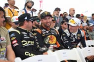 Noah Gragson (#4 Front Row Motorsports Curate Ford), Chase Briscoe (#19 Joe Gibbs Racing Bass Pro Shops Toyota) e Connor Zilisch (#88 Trackhouse Racing Jockey 150th Anniversary Chevrolet) conversam antes da reunião de pilotos no Las Vegas Motor Speedway - Fonte: Getty