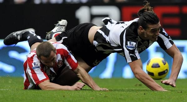 Andy Carroll tussles with Phil Bardsley 