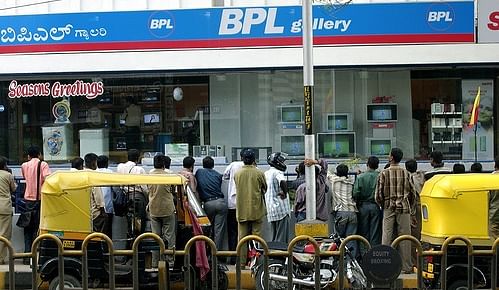 People flock in front of a TV showroom to watch cricket match