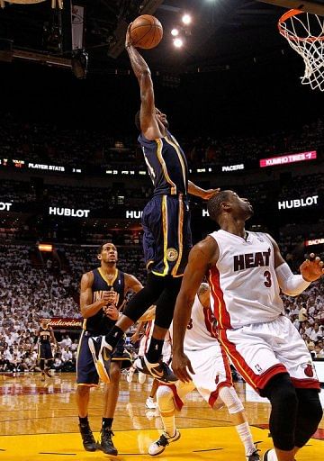 Paul George of the Indiana Pacers dunks over Dwyane Wade of the Miami Heat