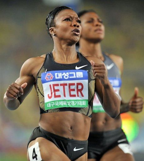 Carmelita Jeter (L) of the US crosses the finish line ahead of Nigeria&#039;s Blessing Okagbare