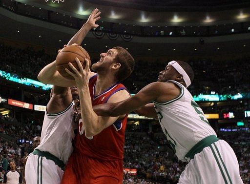 Philadelphia 76ers&#039; Spencer Hawes (C) tries to shoot past Boston Celtics&#039; Paul Pierce (L) and Keyon Dooling