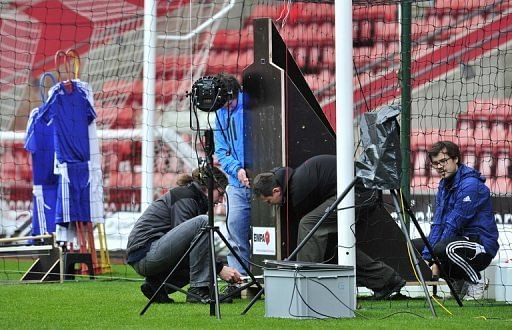 Employees adjust equipment during a test of Hawk-Eye Goal Line Technology at St Mary&#039;s Stadium in Southampton