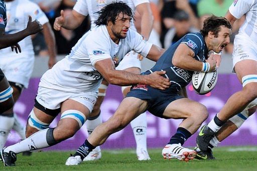 Castres&#039; wing Marc Andreu (R) is tackled by Montpellier&#039;s lock Mickael de Marco