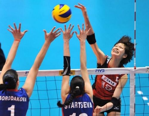 Japan's Saori Kimura (R) spikes the ball over Russia's Maria Borisenko (L) and Evgeniya Startseva