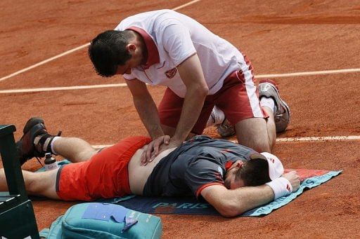 Andy Murray receives treatment for his back injury during the match against Jarkko Mieminen