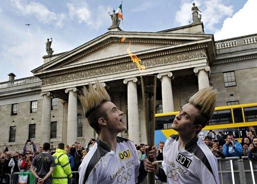 Irish pop stars John and Edward Grimes, known as Jedward, carry the torch during their relay leg