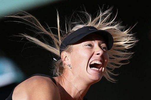 Russia&#039;s Maria Sharapova serves to Czech Republic&#039;s Petra Kvitova