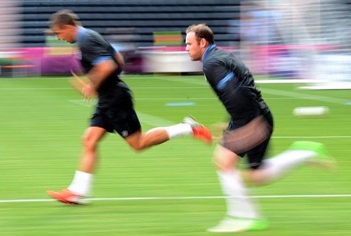 England&#039;s forward Wayne Rooney (R) runs during a training session at the Dombass Arena stadium