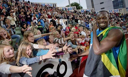 Young spectators cheer and try to touch Jamaican sprinter Usain Bolt after he won the men&#039;s 100m at the Diamond League