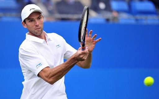 Ivo Karlovic of Croatia returns against Lleyton Hewitt of Australia