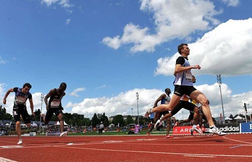 French Christophe Lemaitre (R) crosses the finish line