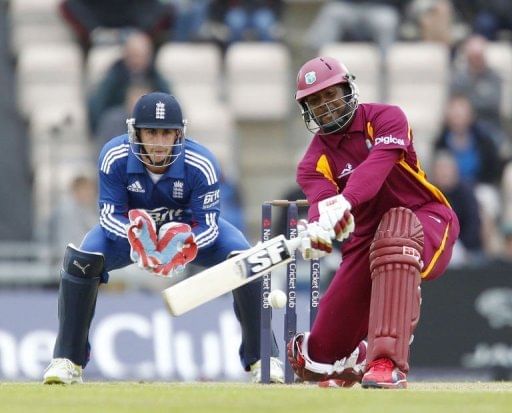 Dwayne Smith of the West Indies (R) hits a shot watched by England&#039;s wicketkeeper Craig Kieswetter