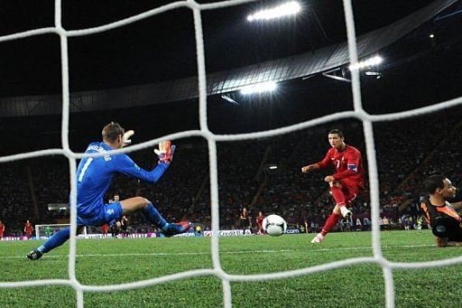 Portuguese forward Cristiano Ronaldo (C) scores past Dutch goalkeeper Maarten Stekelenburg