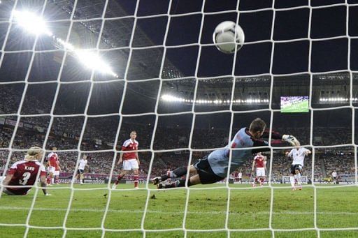 Danish goalkeeper Stephan Andersen (C) fails to save a strike by German forward Lukas Podolski