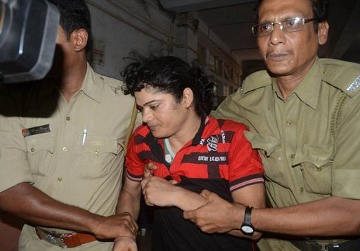 Police escort Indian athlete  Pinki Pramanik (centre) to the Barasat  District court in Barasat