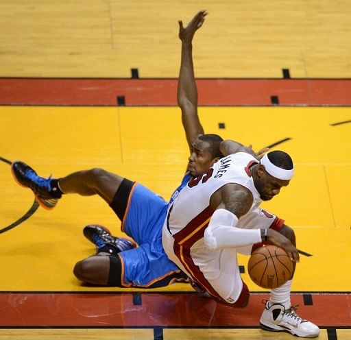 LeBron James (R) of the Miami Heat collides with Serge Ibaka (L) of the Oklahoma City Thunder during Game 3