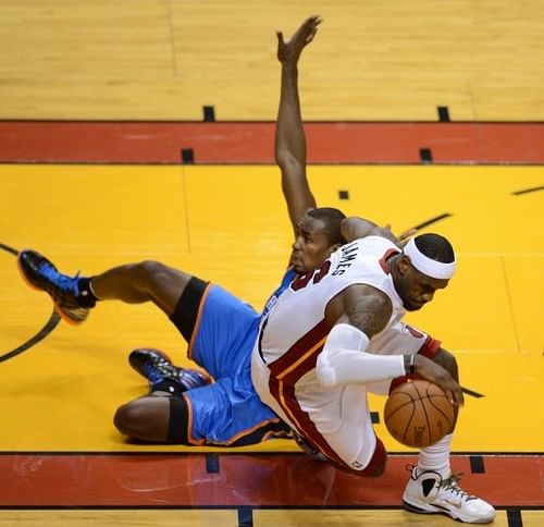 LeBron James (R) of the Miami Heat collides with Serge Ibaka (L) of the Oklahoma City Thunder during Game 3