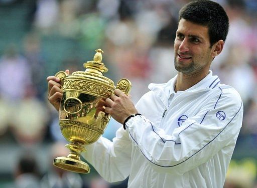 Djokovic holds the trophy after beating Rafael Nadal in last year&#039;s Wimbledon men&#039;s singles final