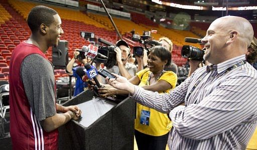 Miami Heat player Mario Chalmers (L) answers questions from reporters during practice