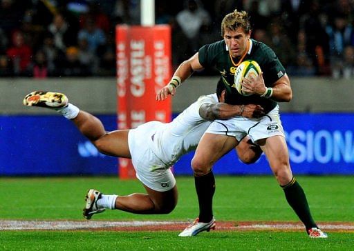 South Africa&#039;s Wynand Olivier (C) is tackled by an England player