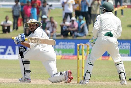 Sri Lankan batsman Tillakaratne Dilshan (left) plays a shot as Pakistan wicketkeeper Adnan Akmal looks on