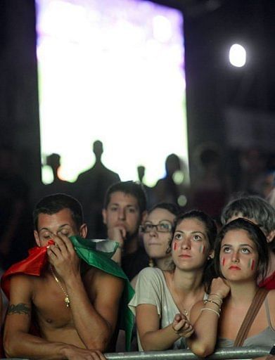Italian supporters react in front of a giant screen