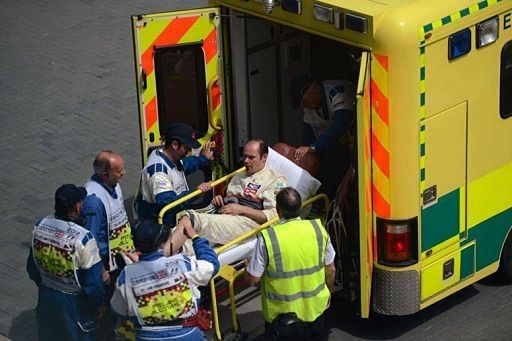 A mechanic from Sauber is put into an ambulance after being hit in the pits