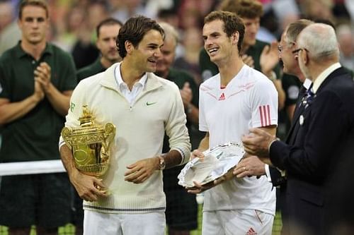 Switzerland's Roger Federer (L) stands with the trophy with runner-up Britain's Andy Murray