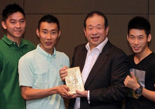 Lee Chong Wei (2ndL) and CEO of Peninsular Gold limited Andrew Kam (2ndR) hold a bar of gold