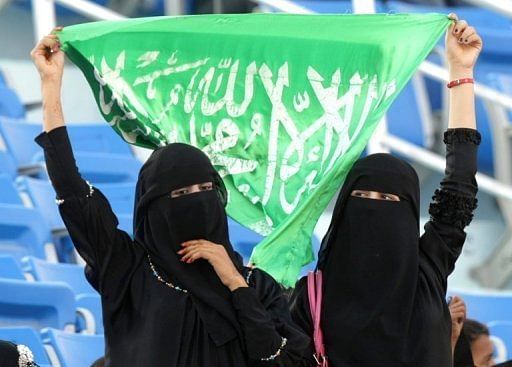 Saudi women hold up their national flag as they watch the opening ceremony of the Gulf Cup in Yemen in 2010