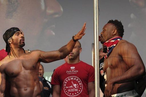 British boxer David Haye (L) gestures to fellow British boxer Dereck Chisora as they face each other across a fence