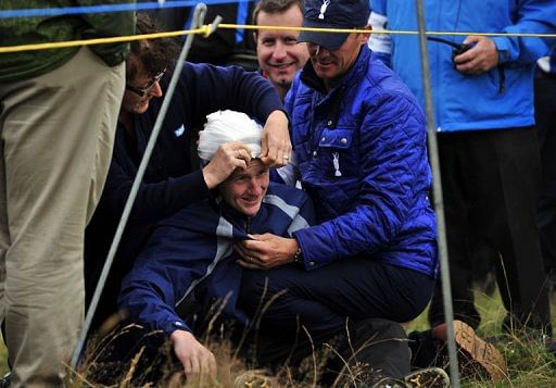 16 year old spectator, Jason Blue is helped after being struck on the head by a ball hit by Rory McIlroy