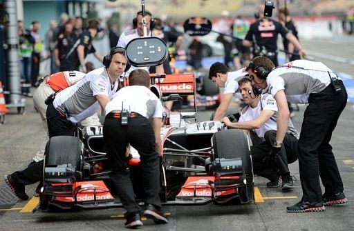 Mechanics push British driver Jenson Button&#039;s McLaren Mercedes&#039; car in the pits in Hockenheim