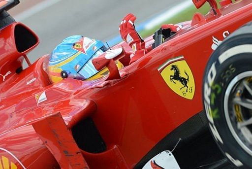 Ferrari&#039;s Spanish driver Fernando Alonso waves after winning at the Hockenheimring circuit