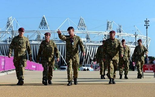 British soldiers walk near the Olympic stadium at the Olympic Park in London