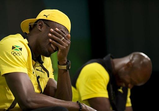 Usain Bolt laughs beside teammate Asafa Powell