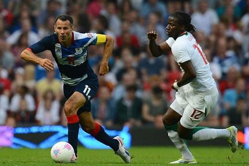 Senegal's Ibrahima Balde (R) vies with Britain's midfielder Ryan Giggs