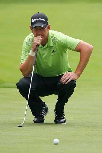 Greg Owen of England lines up his birdie putt on the ninth hole during the first round