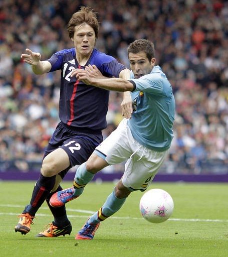 Japan's Gotoku Sakai (left) challenges Spain's Jordi Alba