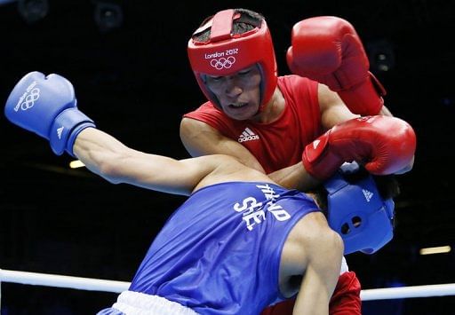 Gani Zhailauov (in red) of Kazakhstan defends against Saylom Ardee (in blue) of Thailand during their match on Sunday