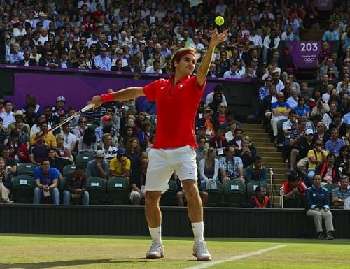 Switzerland's Roger Federer serves to US John Isner