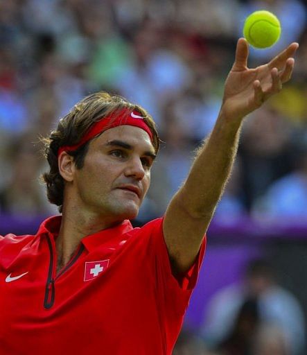 Switzerland&#039;s Roger Federer serves to US John Isner
