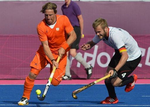Roderick Weusthof (L) of Netherlands dribbles past Maximilian Mueller (R) of Germany