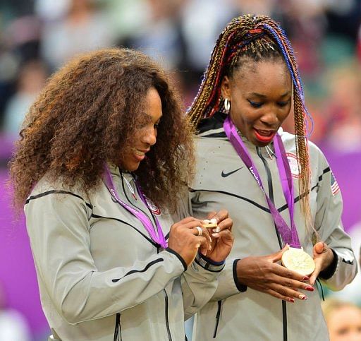 US Serena Williams (L) and Venus Williams stand on the podium after receiving their gold medals