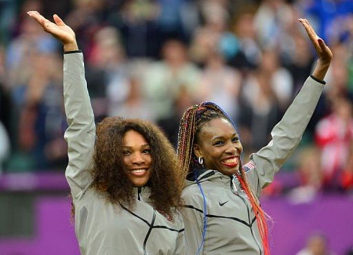 US Serena Williams (L) and Venus Williams celebrate on the podium after receiving their gold medals