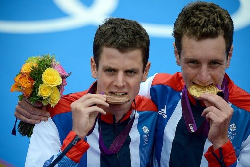 Alistair Brownlee (right) and his brother bronze medallist Jonathan Brownlee bite their medals