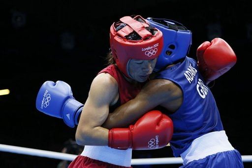 M.C. Mary Kom of India (in red) defends against Nicola Adams of Great Britain